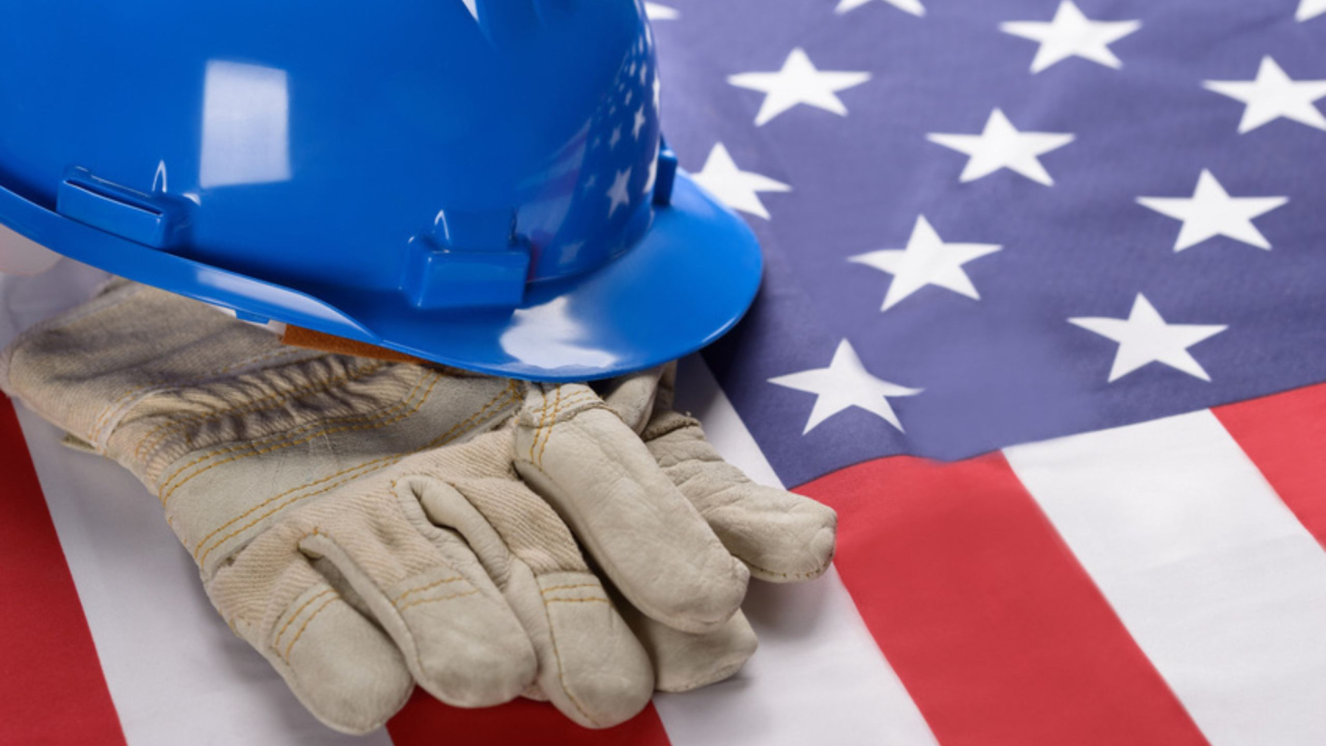 Bild von einer USA-Flagge mit Bauhelm und Handschuhen