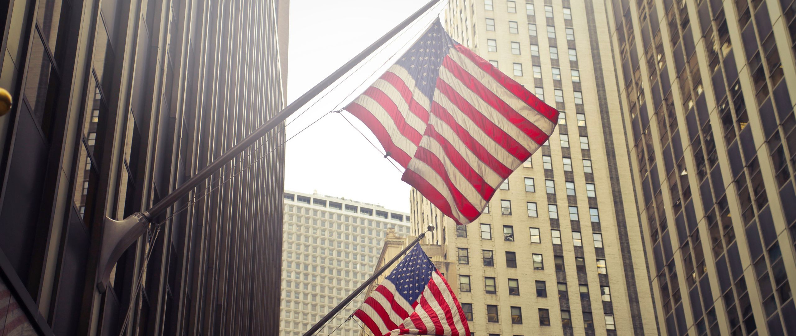 Bild von zwei USA-Flaggen an Wolkenkratzern